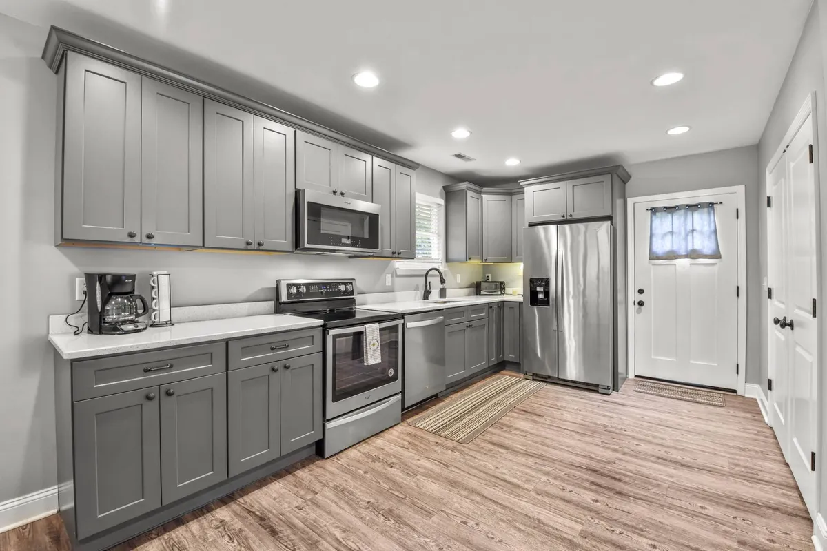 A bright, welcoming kitchen featuring stainless steel appliances, sleek grey cabinetry, and a spacious countertop area. The scene feels inviting and functional, ideal for meal preparation and family gatherings. The modern fixtures and clean lines highlight the kitchen's contemporary style.